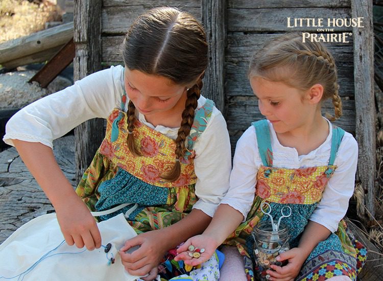 Sewing buttons on a sampler - I love these Little House on the Prairie inspired activities for kids!