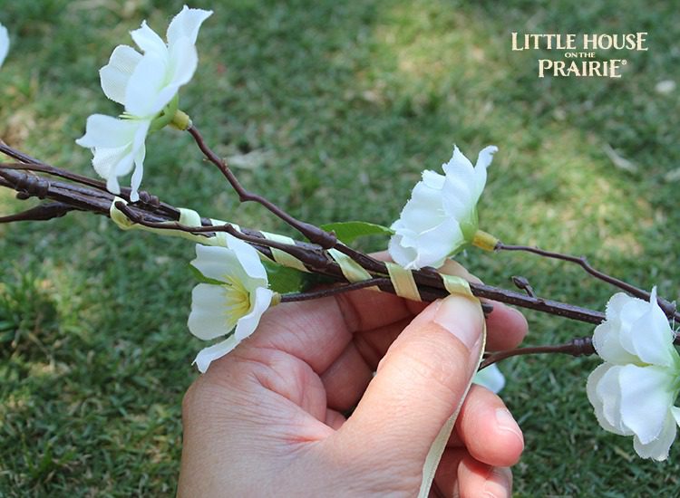 Wrap the ribbon around the entire flower wreath to cover the stems.